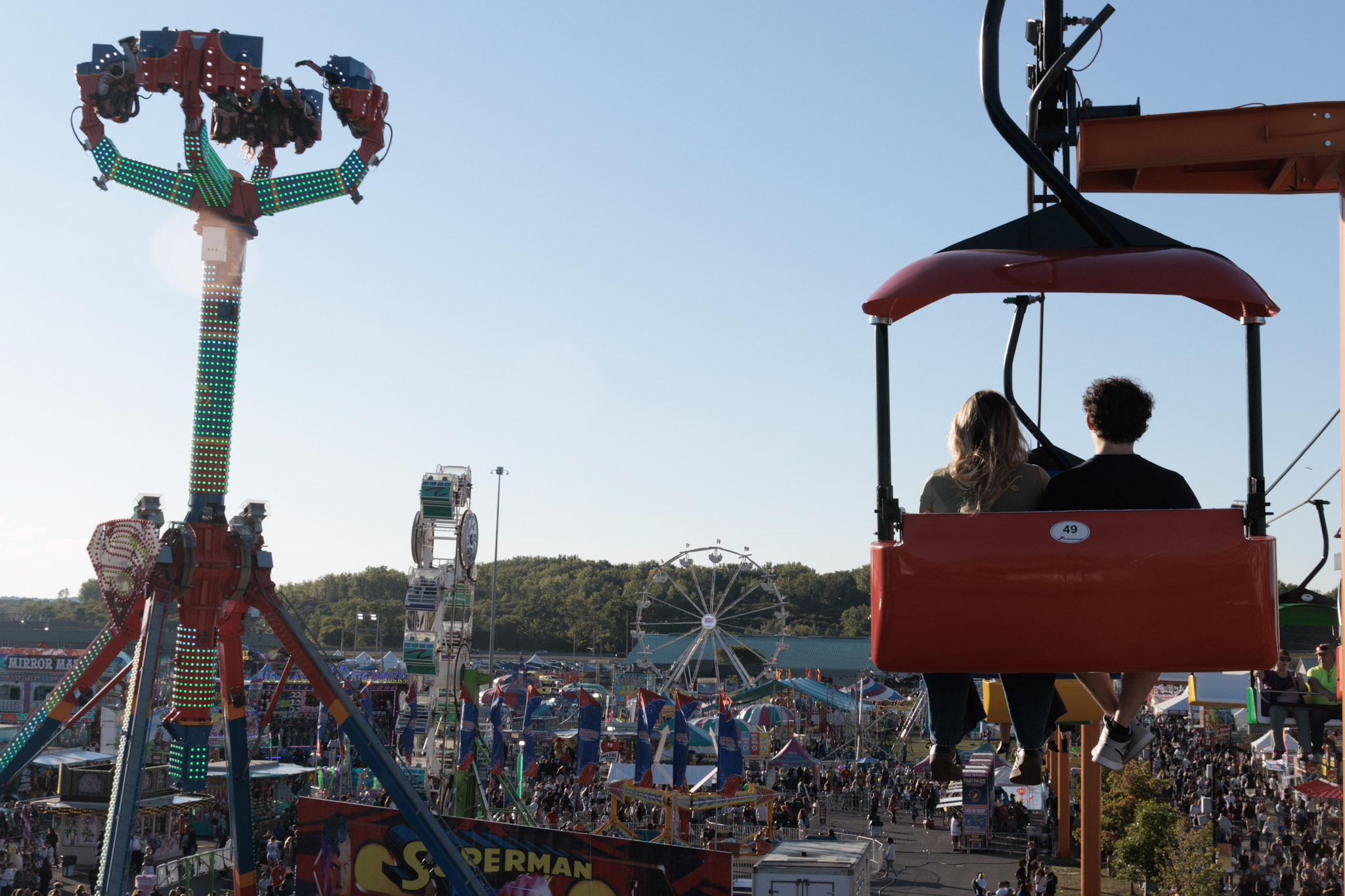 Fair goers sit on a ride overlooking the fair grounds