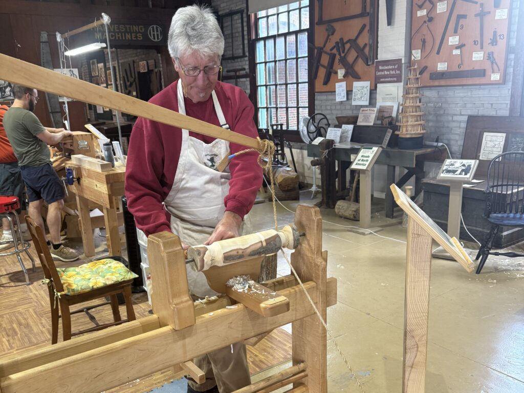 Charlie LaPrease of Woodworkers of Central New York cutting wood using the Spring Pole Lathe at the New York State Fair