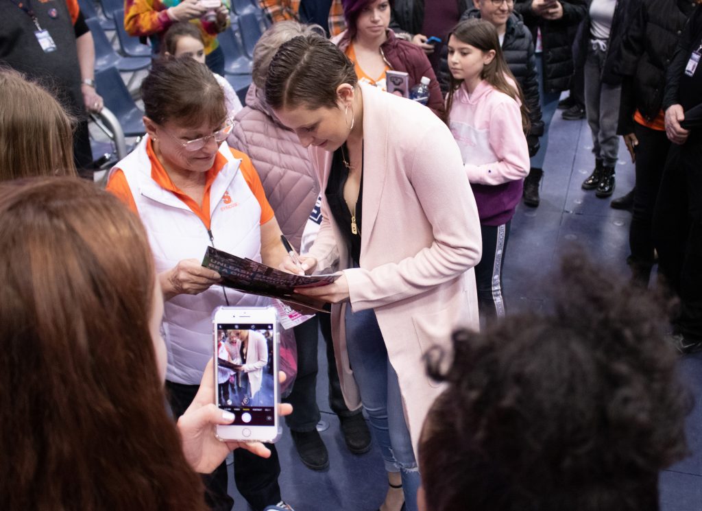 Syracuse University's guard, Tiana Mangakahia, signs a game pamphlet for a fan after a college basketball game against the University of Pittsburgh. Tiana Mangakahia is a breast cancer survivor and the Syracuse women's basketball team tried to raise awarness about the disease by encouraging fans and players to wear pink during Sunday's basketball game.