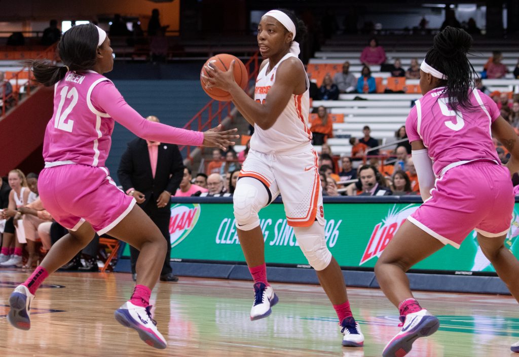 Syracuse University's guard, Kiara Lewis, 23, looks to pass the ball to her teammates as Pitt's Gabbie Green (12) and Amber Brown (5) defend during a college basketball game against the University of Pittsburgh on February 20.