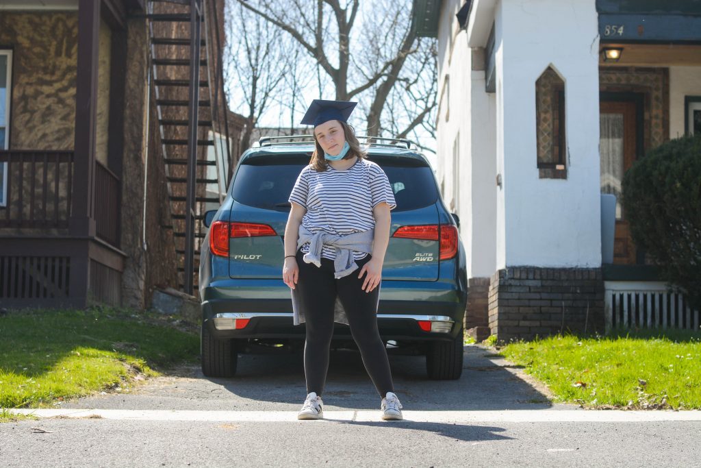 Allison Ingrum stands with graduation cap and face mask