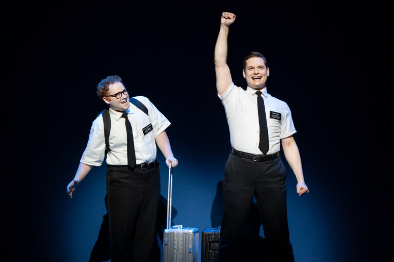 In "The Book of Mormon" two excited Mormon missionaries stand with suitcases ready to embark on their mission.