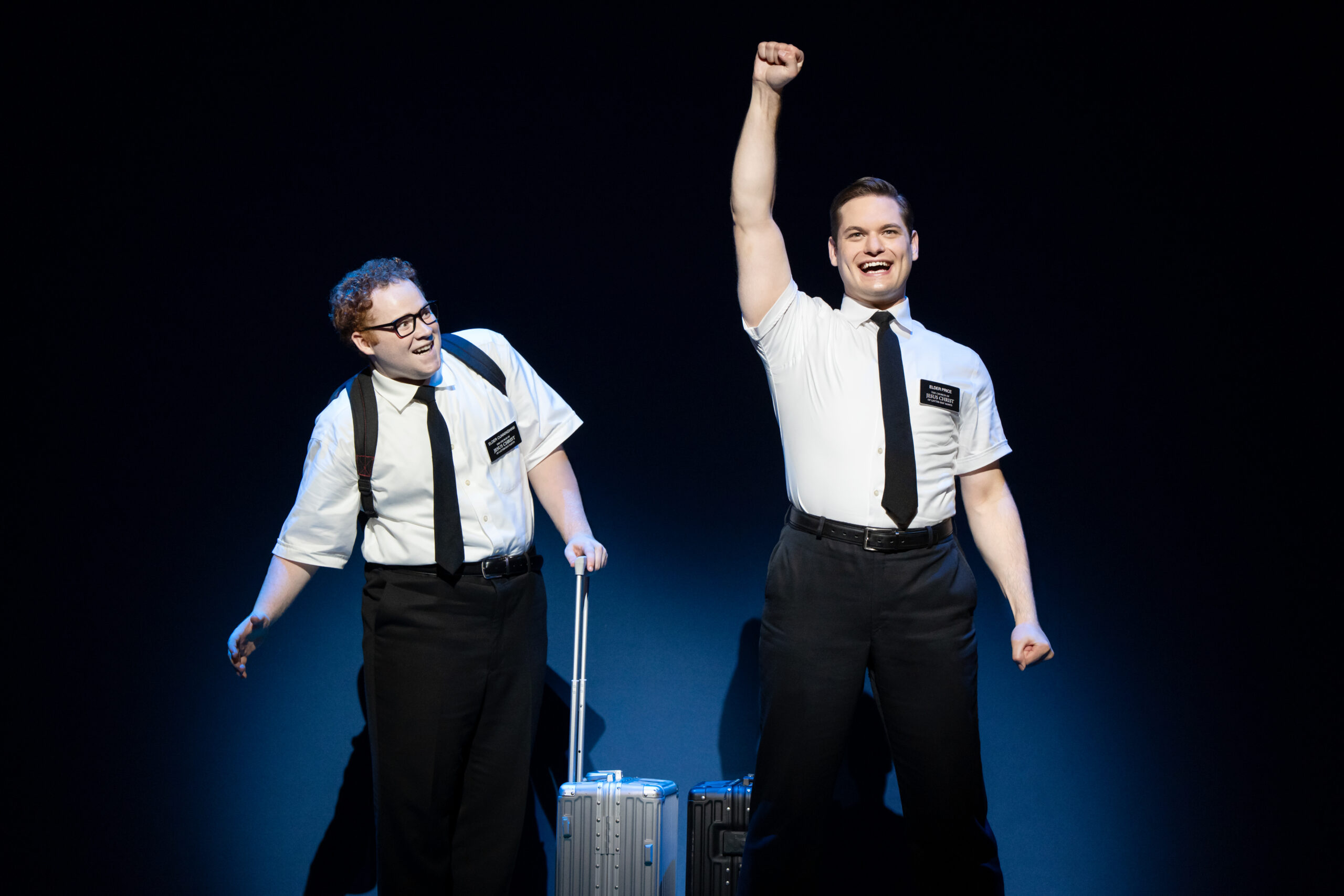 In "The Book of Mormon" two excited Mormon missionaries stand with suitcases ready to embark on their mission.