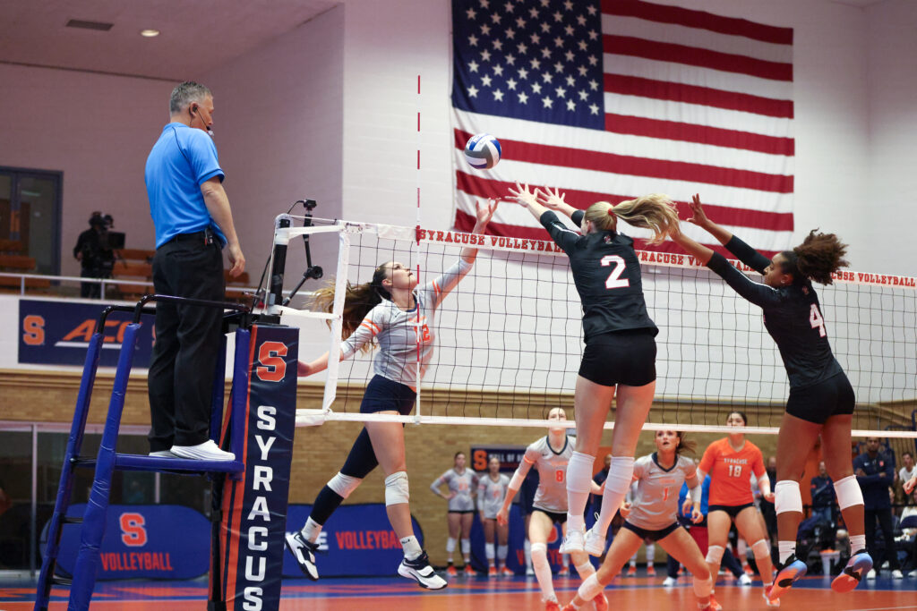 Syracuse right-side Keila Gabriel (12) attempts to tip the ball past Louisville defenders during a college volleyball game between the Louisville Cardinals and the Syracuse Orange on September 25, 2026, in Syracuse, NY (Photo by Brody Shuffler/Newshouse)