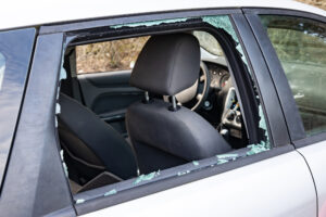 Vehicle with a completely shattered rear passenger window after burglary
