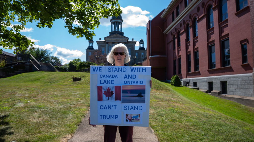 A local holds a sign in Oswego, New York, sharing her stance on President Trump's executive order renaming Lake Ontario to 