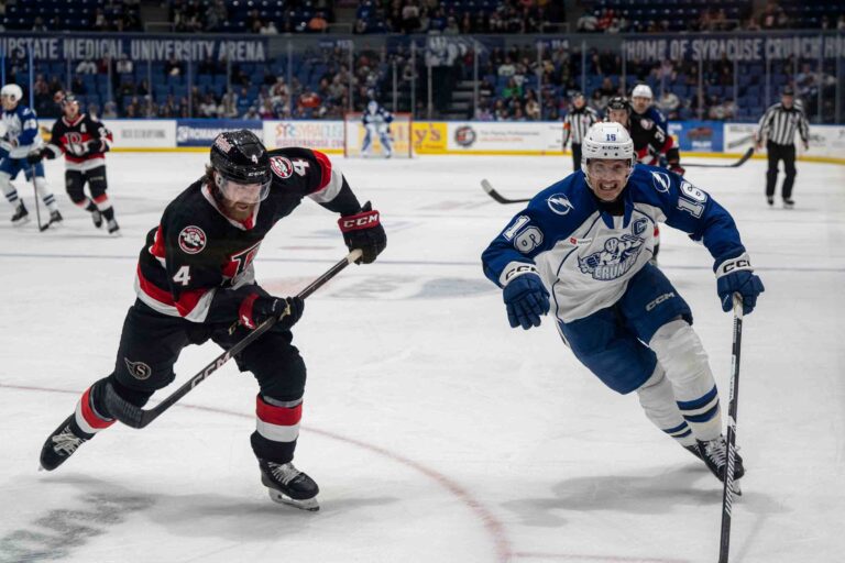 Defensman Steven Santini (16) skates down the ice with Defenseman Cameron Crotty (4) during the Syracuse Crunch game against the Belleville Senators on November 1, 2025, at Upstate Medical University Arena at the Oncenter War Memorial in Syracuse, New York.