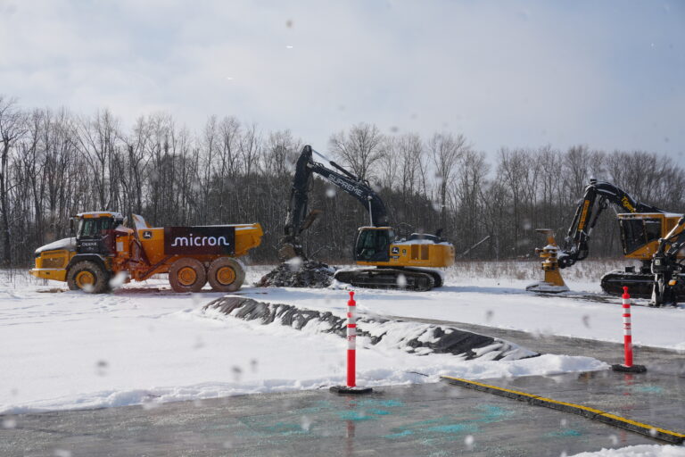 Micron excavator vehicles stand outside the groundbreaking ceremony to perform the first major dig on the land set for the Metafab construction on Jan. 16, 2026