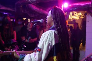 Artist BRI performing at a basement concert put on by the Garden