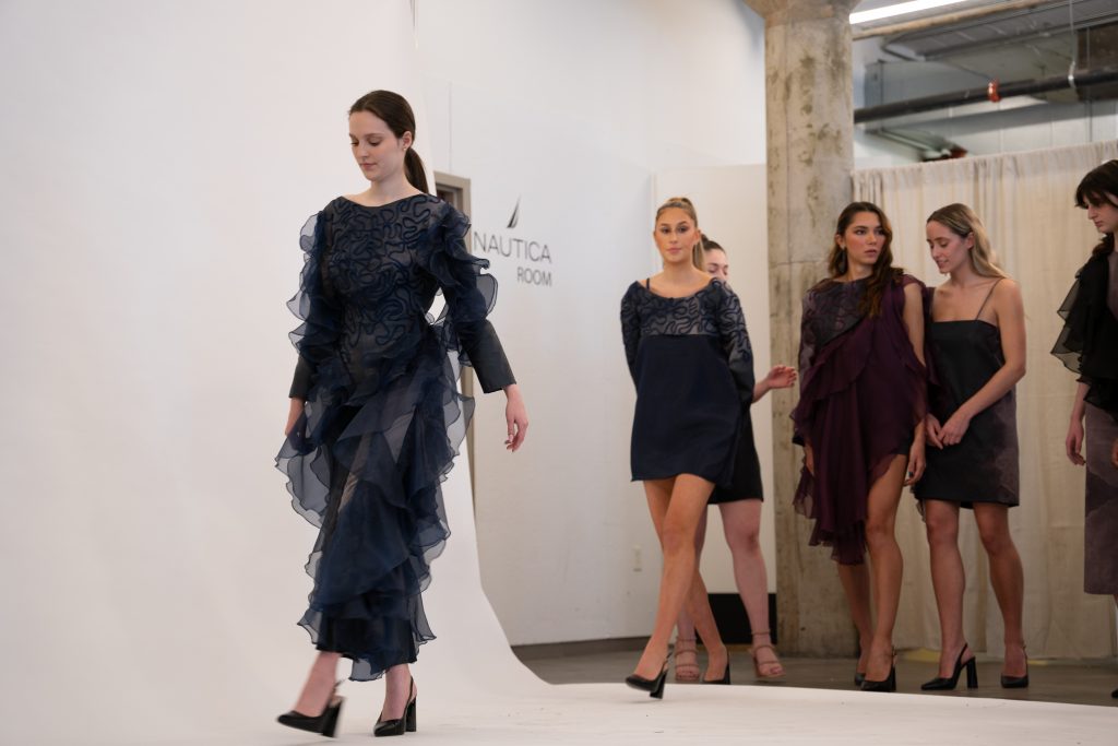 Models step onto a white photo backdrop during FADS organization's