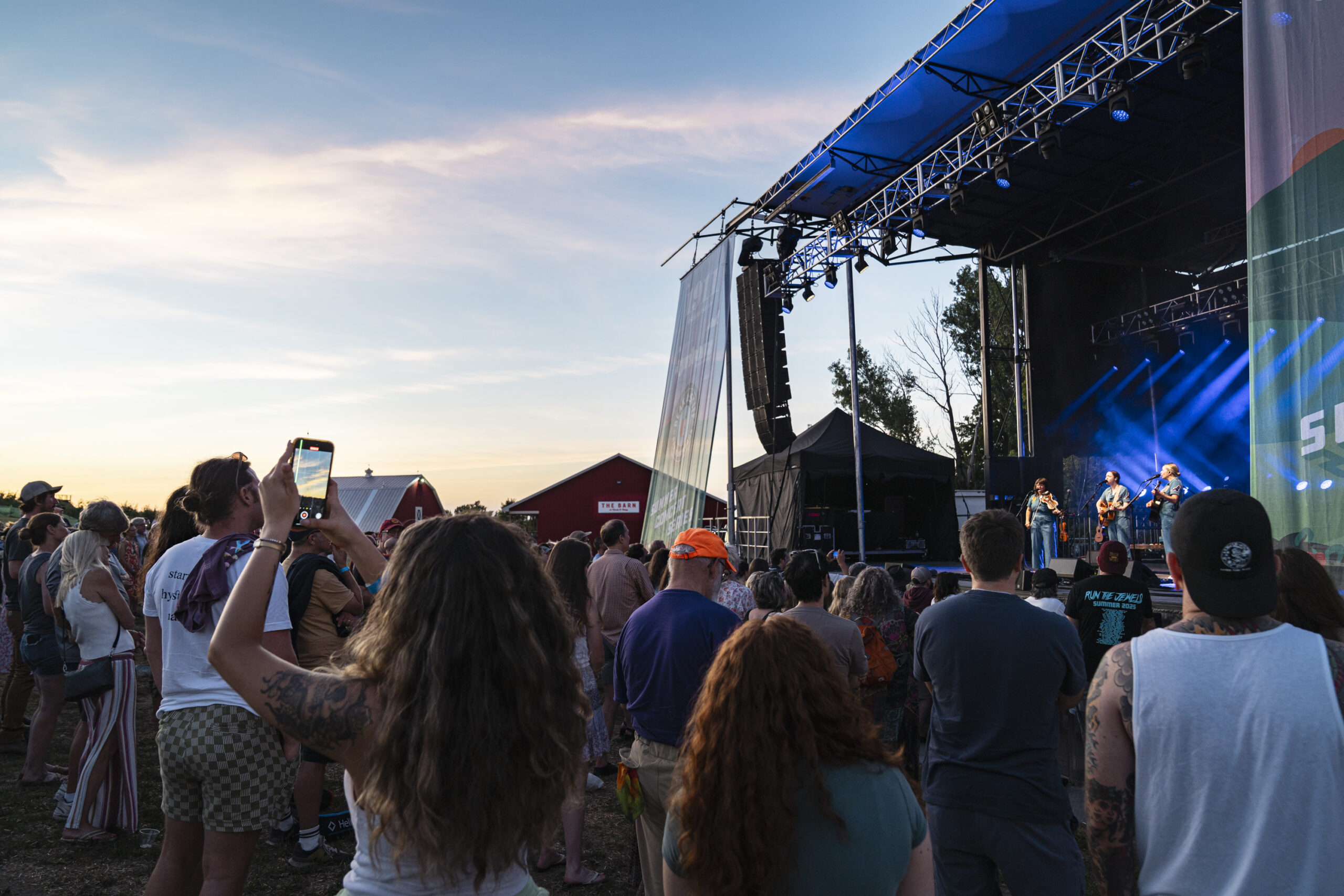 The sun sets behind Beak & Skiff Apple Orchards in Lafayette, N.Y., during a summer concert featuring Iron & Wine and I’m With Her on Friday, July 25, 2025.