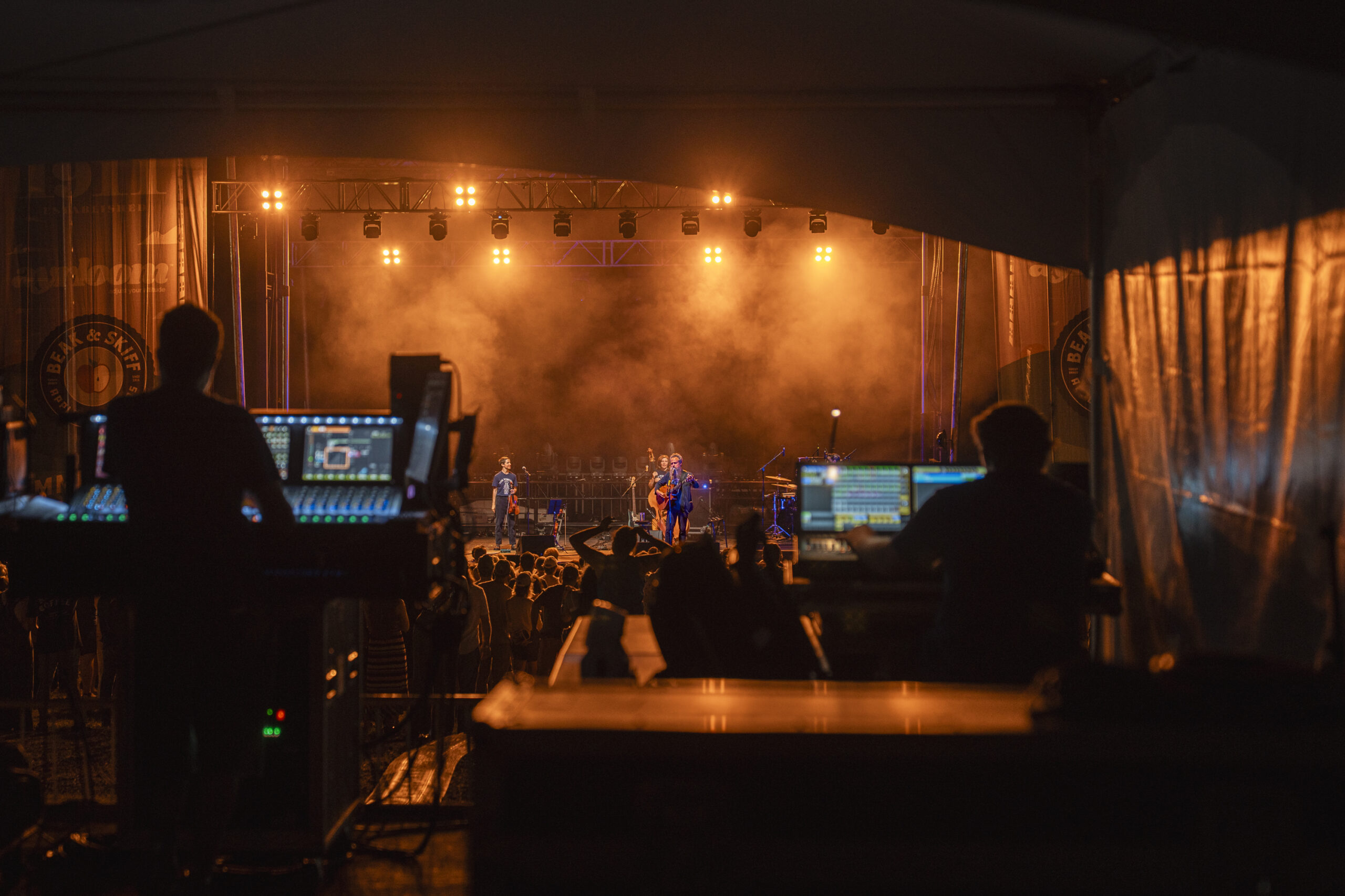 Light and sounds engineers monitor levels across from the stage during Iron & Wine’s performance at Beak & Skiff Apple Orchards. From mixing vocals to balancing instrumentation, the crew helped bring Sam Beam’s folk sound to life.