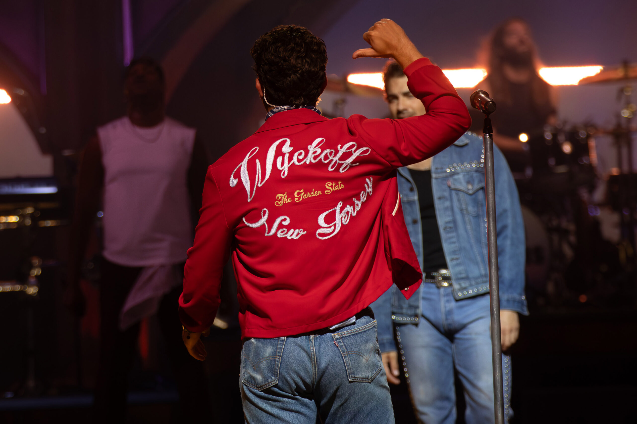 Nick Jonas motions to his jacket, which displays his hometown of Wyckoff, NJ, during the JONAS20: Greetings From Your Hometown Tour at Empower Federal Credit Union Amphitheater at Lakeview in Syracuse, NY on Tuesday, Aug. 19, 2025. Photo by Kayla Breen.