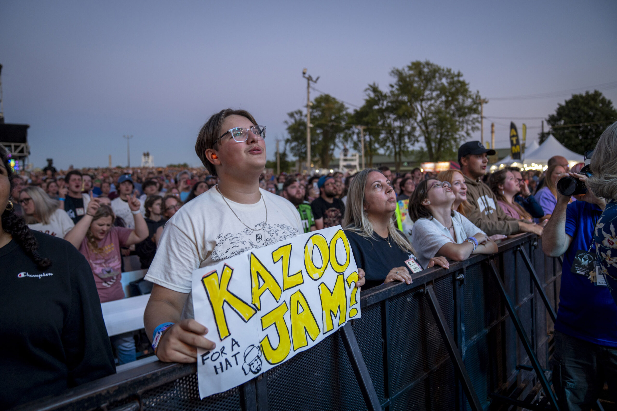 Fans pressed to the barricade hold a handmade “Kazoo Jam?” sign, a playful nod to AJR’s love of oddball instruments at the New York State Fair on Thursday, Aug. 21, 2025