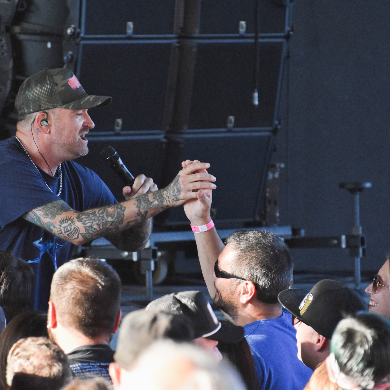 New Found Glory lead singer Jordan Pundik grabs the hand of a fan in the pit during The Offspring's 2025 Supercharge Tour concert on July 22, 2025, at Empower FCU Amphitheater.