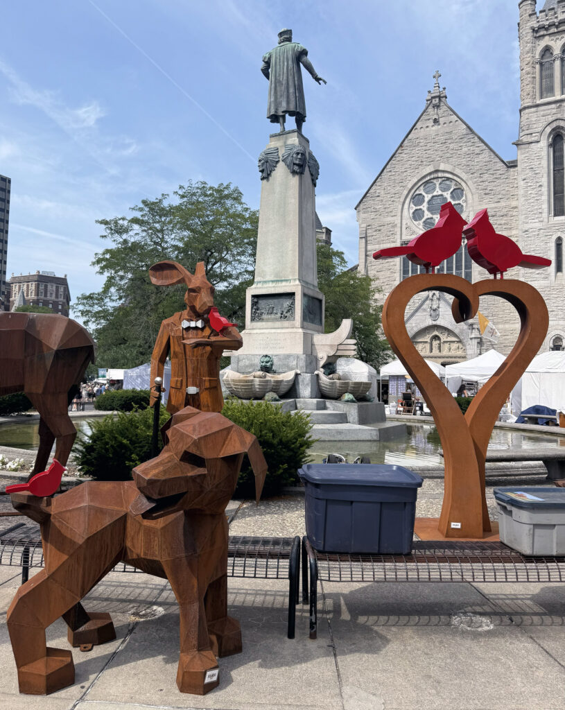 Giant, hand-carved sculptures are for sale near downtown Syracuse's Columbus Circle during the Syracuse Arts & Crafts Festival.