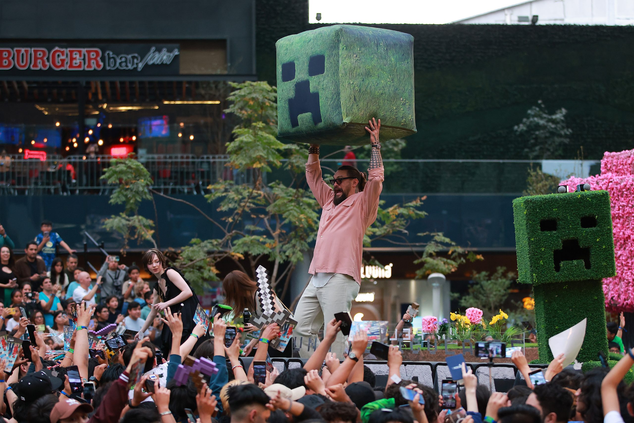 NAUCALPAN DE JUAREZ, MEXICO - MARCH 22: Jason Momoa, actor, throws a prop during the fan event for 'A Minecraft Movie' at Plaza Parque Toreo on March 22, 2025 in Naucalpan de Juarez, Mexico. (Photo by Manuel Velasquez/Getty Images)