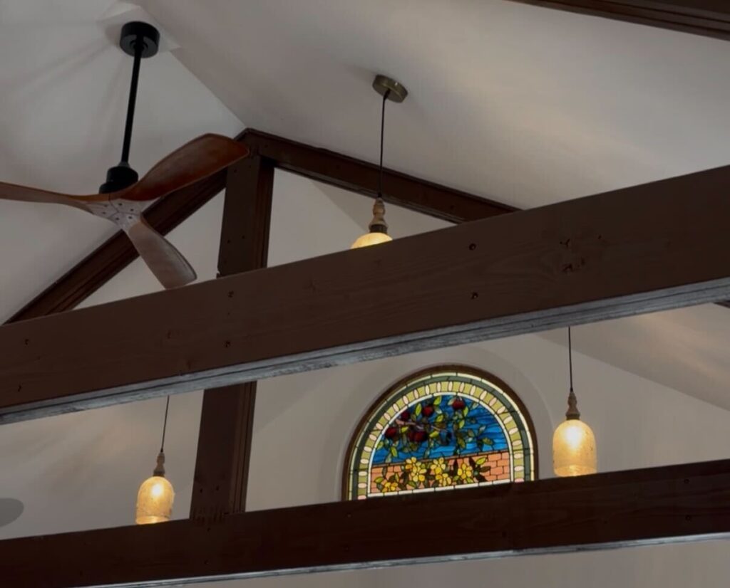 Ceiling of a bakery establishment that showcases a stain-glass window.