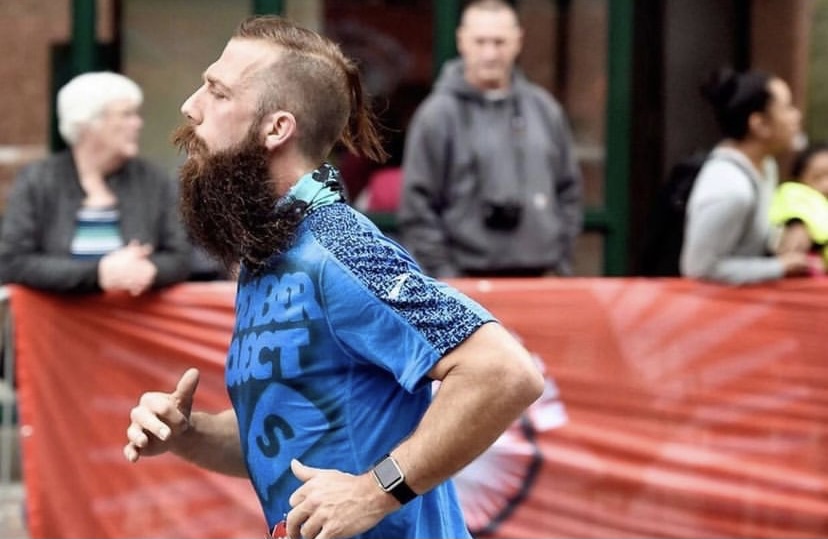 Nick Burger sports a November Project Syracuse tagged shirt while running a race.