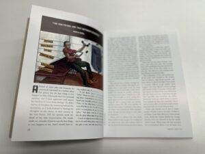 The inside of a magazine is shown with text and a cartoon image.