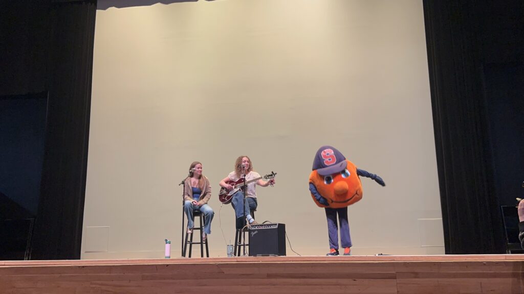 Otto dances on stage with performers at a Women's History Month celebration at Schine Auditorium Friday.