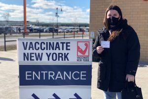 Leah Dunne holds her vaccination card after receiving her first dose of the COVID-19 vaccine at the New York State Fairgrounds.