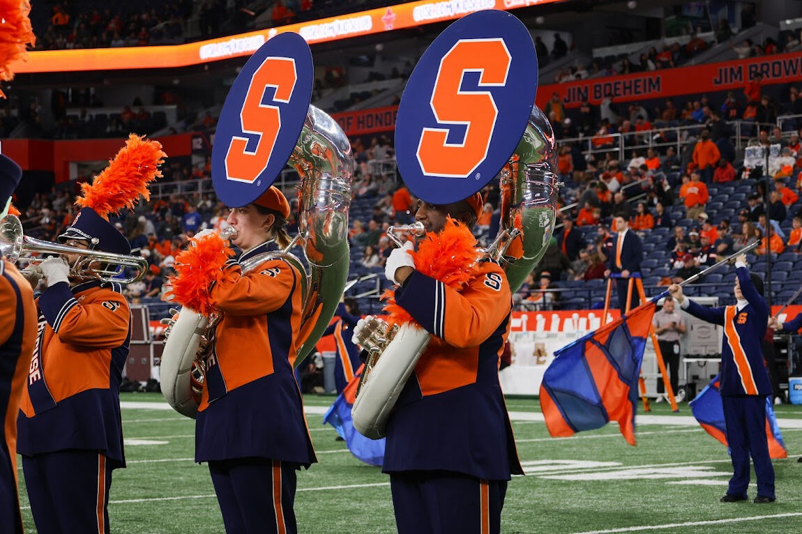 Michael Gaither, right, playing his trombone for the Syracuse University Marching Band in the JMA Wireless Dome.