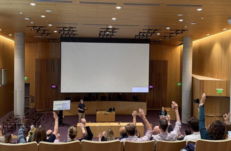 University Senate members raise their hands during the first session of the year.