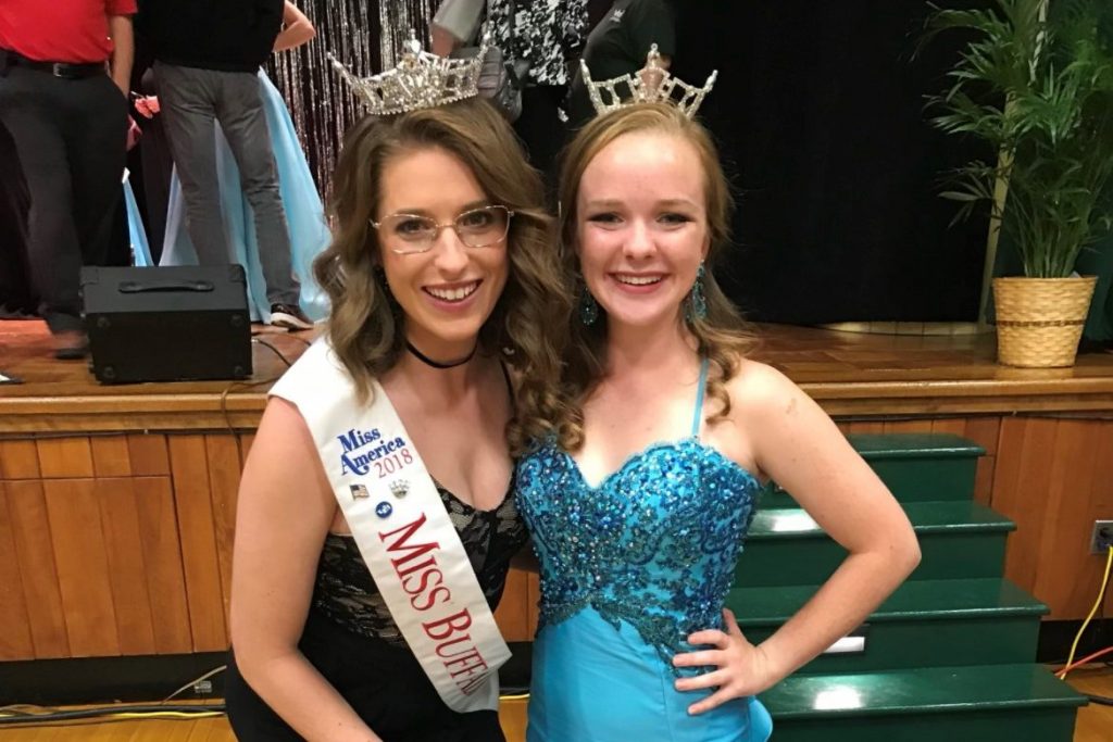 Nina Zesky and Clara Tyrel posing for a photo while wearing their crowns