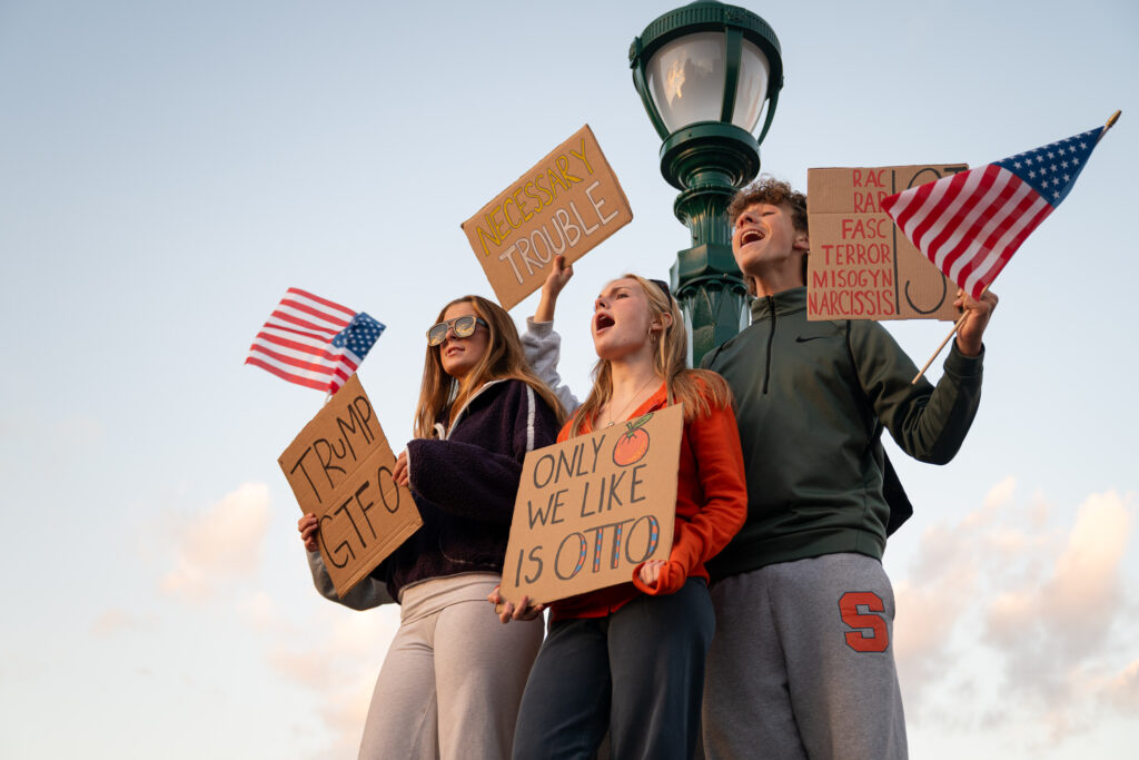 Protesters hold signs during an anti-Trump demonstration at Clinton Square in Syracuse, N.Y., on Oct. 9, 2026.