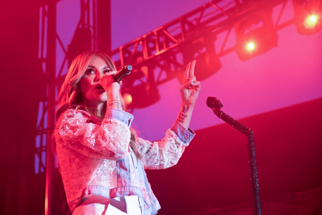 Carly Pearce sings under pink lighting at Suburban Park on Wednesday.