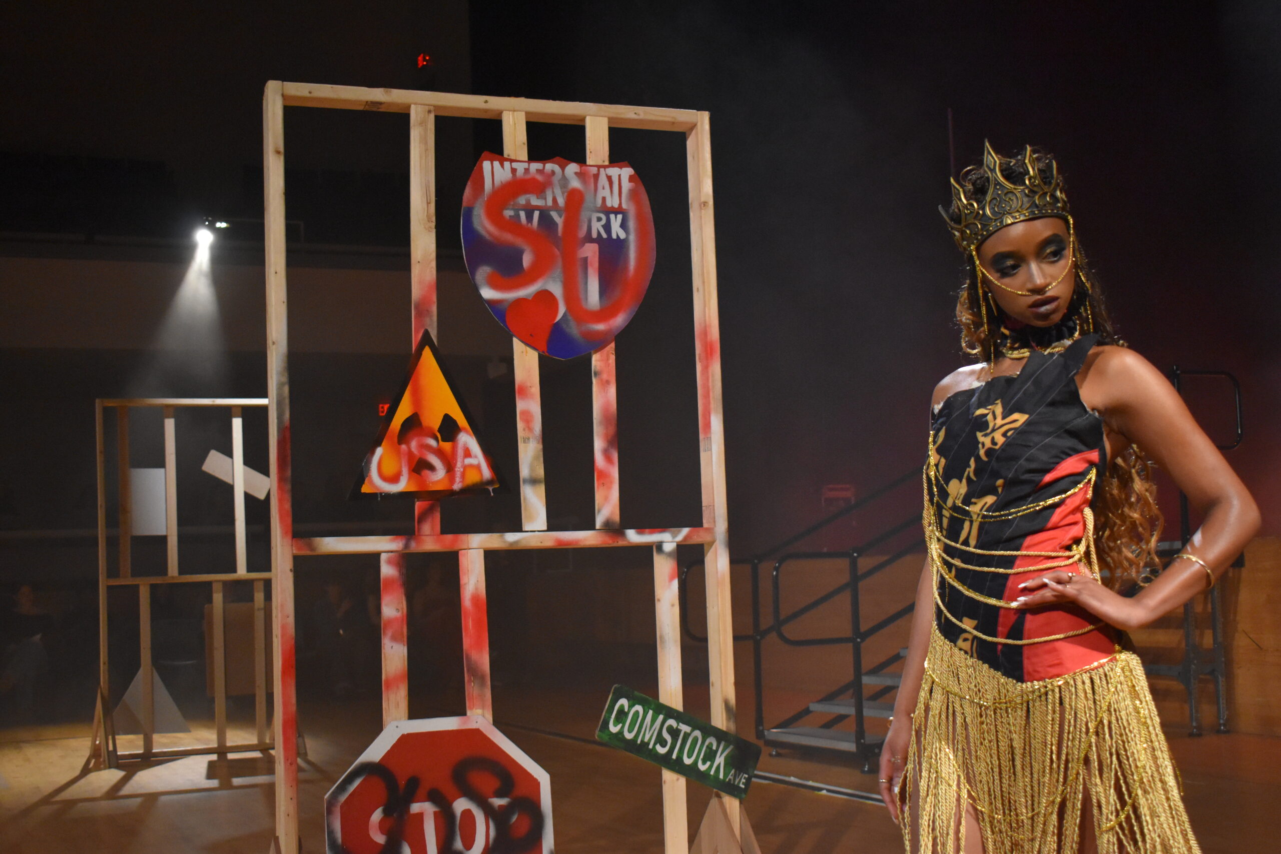 fashion show model in a tight shirt and skirt in front of a grafittied panel