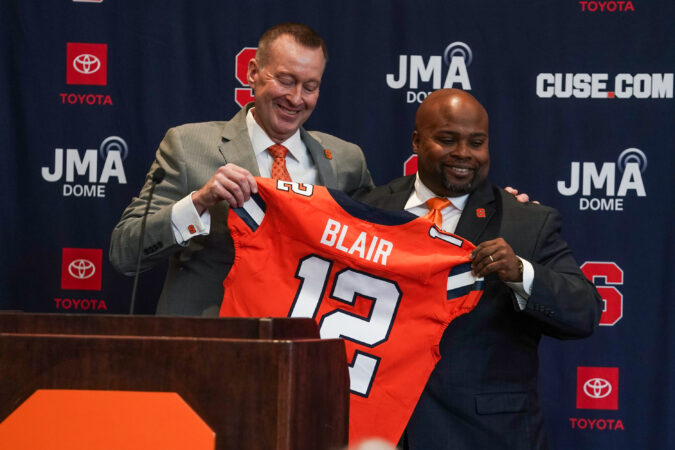 New Syracuse Athletic Director Bryan Blair receives a custom football jersey from Chancellor Mike Haynie during Blair's announcement ceremony at the Miron Victory Court on Thursday, March 19, 2026.