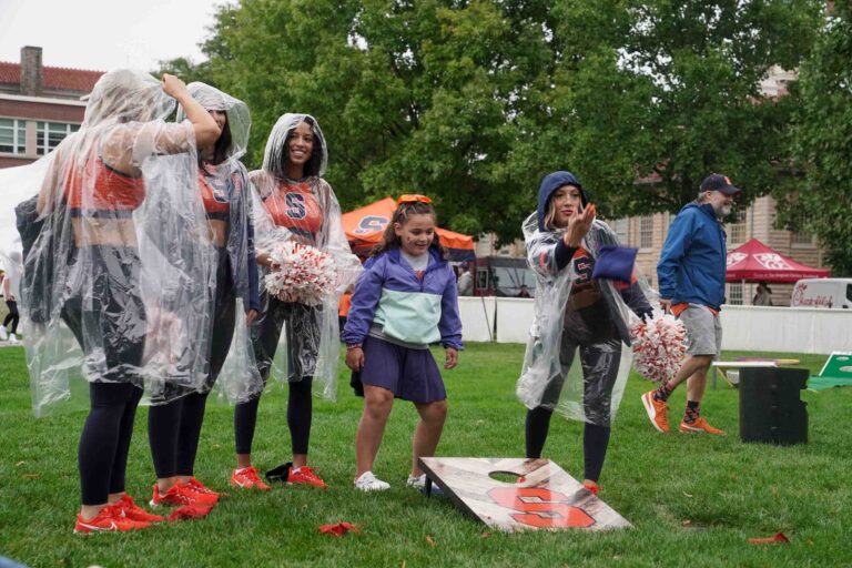 Syracuse fans and cheerleaders play cornhole on campus during the 'Cuse on the Quad tailgate event Saturday before the football team's home opener game against UConn. (Photo by Jack Henry / Newhouse School)