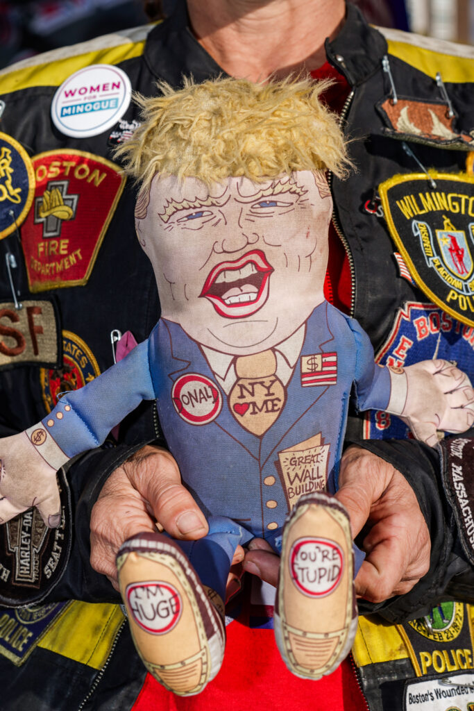An attendee of the Trump rally holds a plush Trump doll outside of the Oncenter on Friday, Oct. 9, 2026.