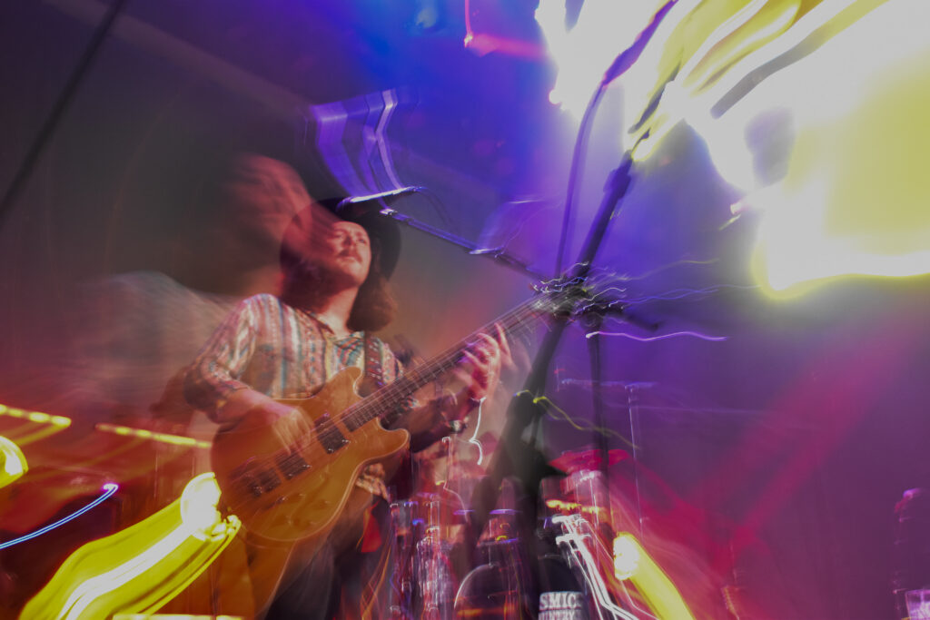 Daniel Donato's Cosmic Country bassist playing on stage, photo with psychedelic effect