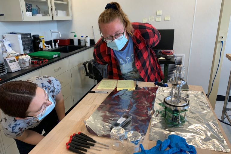 Paleoclimate Dynamics Lab members Steph Bullinger (left) and Claire Rubbelke (right) work on replacing a filament in an ion source — a device that helps ionize gases to measure isotopes of different elements precisely.