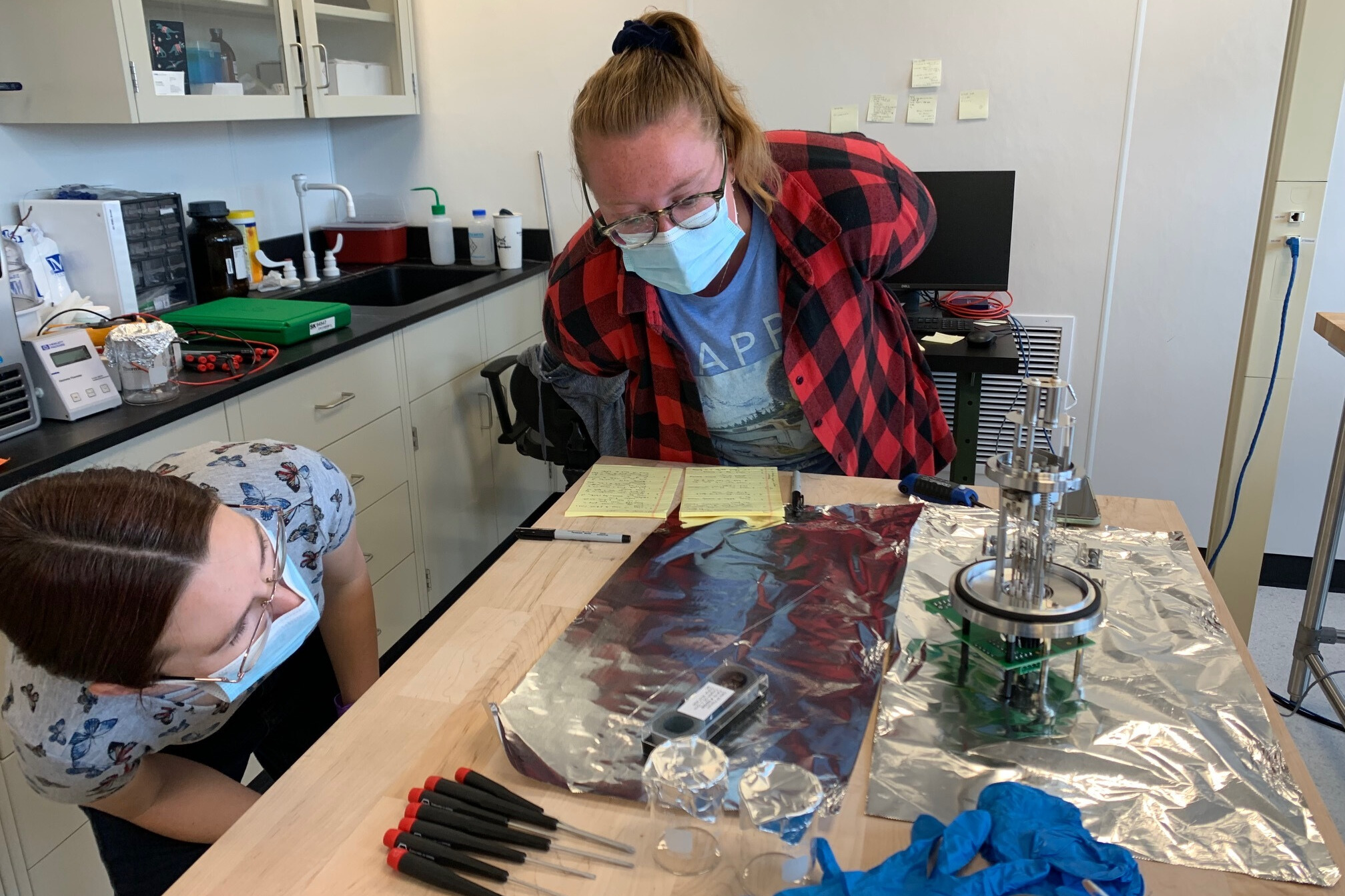 Paleoclimate Dynamics Lab members Steph Bullinger (left) and Claire Rubbelke (right) work on replacing a filament in an ion source — a device that helps ionize gases to measure isotopes of different elements precisely.