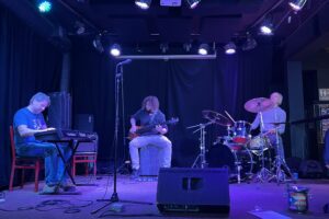 At the weekly Jazz Jam event at Funk n' Waffles, a band consisting of keyboard, bass and drums play onstage.