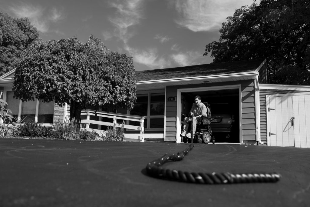 October 11th, 2020. Joseph Pagano exercises his core by pulling a heavy rope, an exercise his daughter recommended to him. Because of his limited mobility, exercise is important as his core strength is what allows him to lift himself out of his chair and support himself.