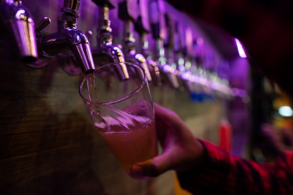 A bartender at Buried Acorn Brewing pours a glass from a tap on September 10th, 2021.
