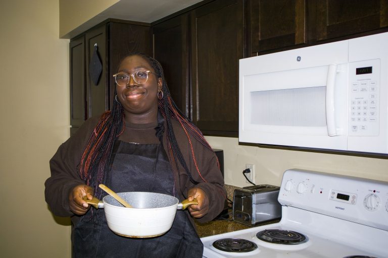 Zoe Selesi makes curry in her apartment.