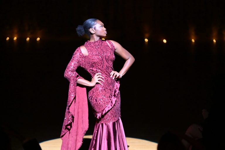 Student model striking a pose in dress designed by featured student designer during RIP the Runway.