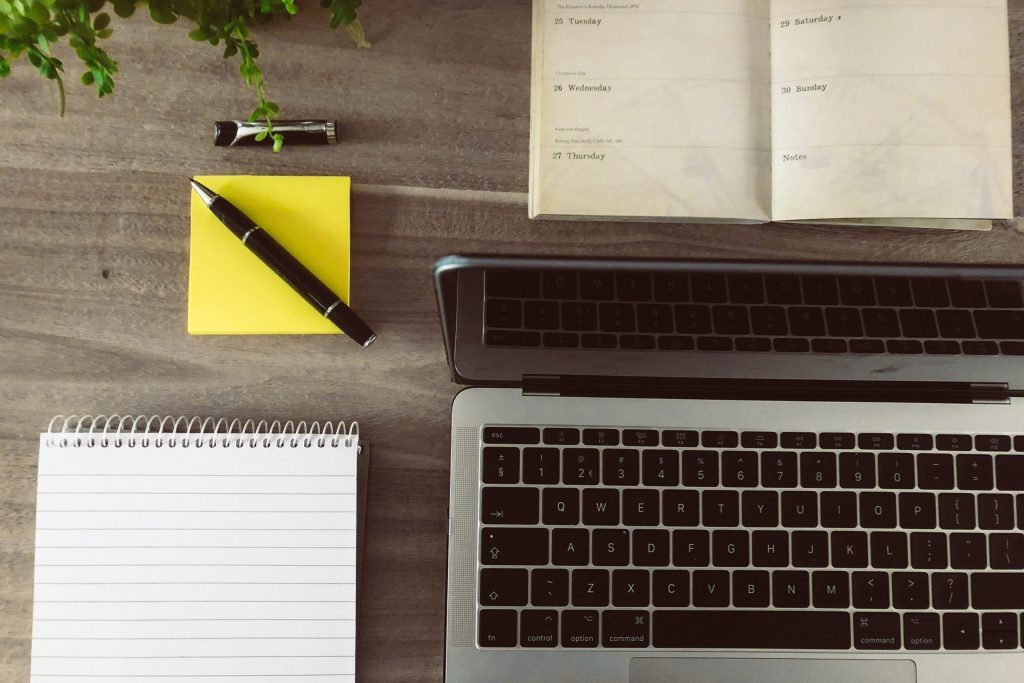 a computer and notebooks on a table