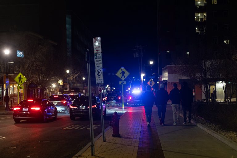 A group of college guys walk down South Crouse Avenue to the bars towards a police car in Syracuse, NY late on December 2nd, 2022.