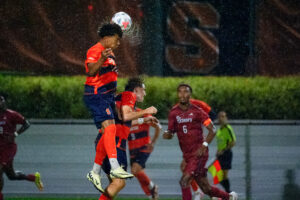 Forward Dario White goes up for a header in the rain in the Syracuse men's soccer game against St. John's on Wednesday, Sept. 9, 2026, at SU Soccer Stadium.