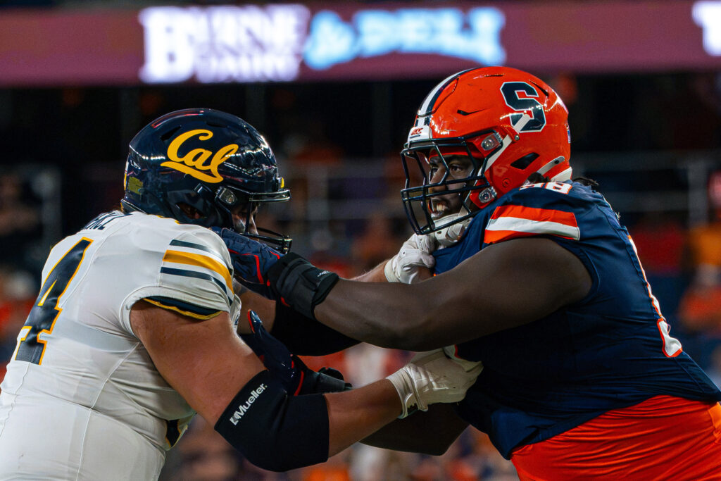 Syracuse offensive lineman pushes off California defensive lineman during an NCAA college football game against the California Golden Bears on Sept. 12, 2026, in the JMA Wireless Dome.