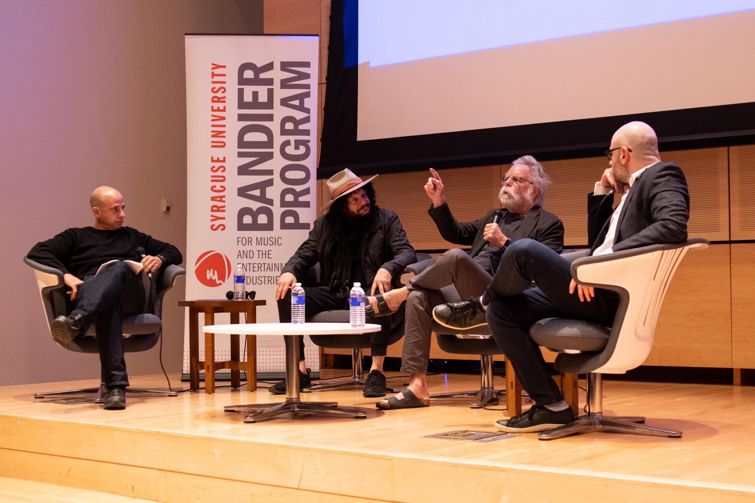Kraig Fox, left, Don Was, Bob Weir and Bill Werde, speak to a group of faculty and students at the Joyce Hergenhan Auditorium on Nov. 7, 2018. Fox, Was and Weir spoke as part of the Bandier Program's David M. Rezak Lecture Series. (Photo by Todd F. Michalek / The NewsHouse)