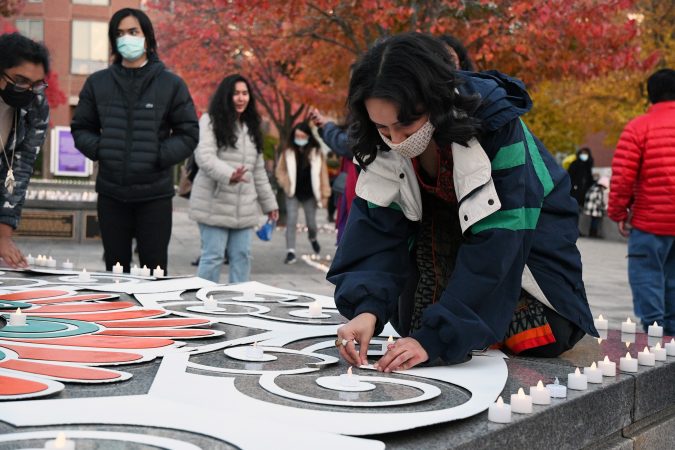A young woman adjusts a white swirl of fiberglass.