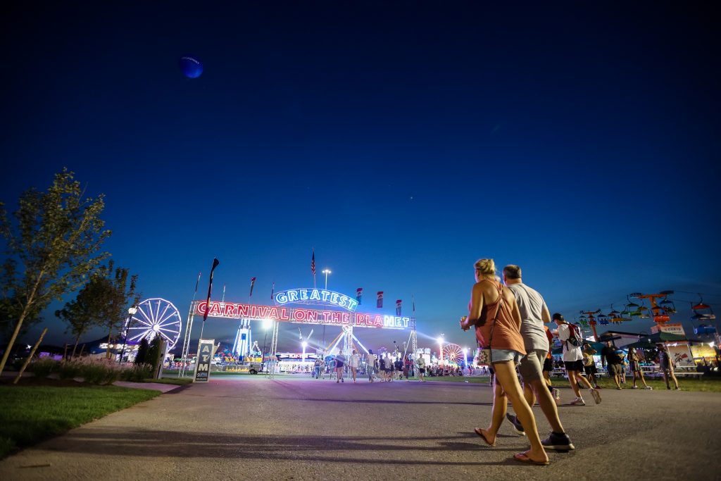 A pair of fairgoers walk toward Midway at the New York State Fair.